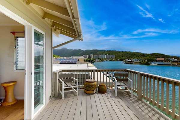 Upstairs primary suite opens directly onto a waterfront balcony