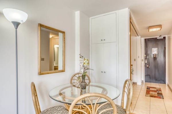 Compact Dining Area Near Entryway with Glass-Top Table and Rattan Chairs