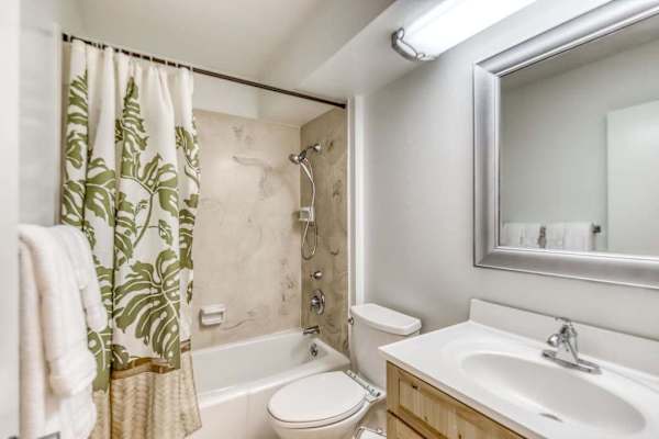 Full Bathroom with Combination Tub-Shower, Vanity, and Large Wall Mirror
