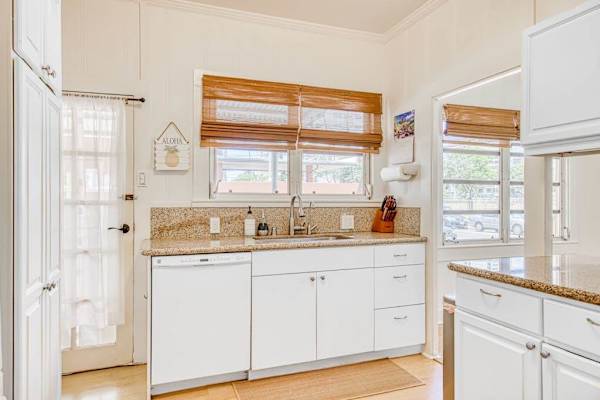 White kitchen features ample cabinetry and generous counter space