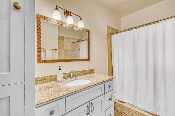 Full bathroom offers a shower and tub combination with bright vanity lighting