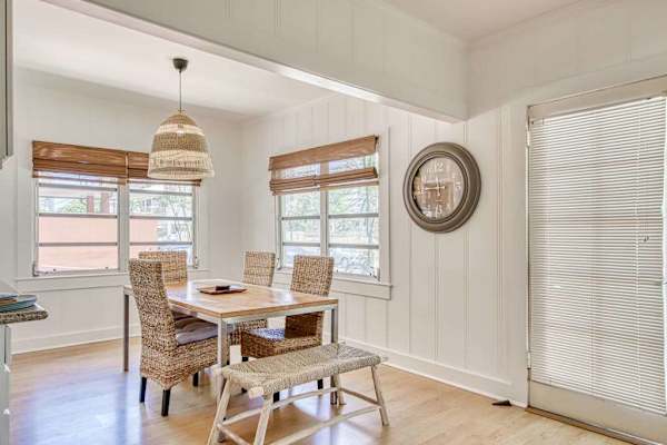 Gather around the window-side dining table beneath a woven pendant light