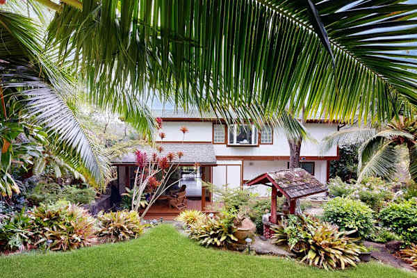 Arrive home to a welcoming entrance surrounded by lush tropical greenery.