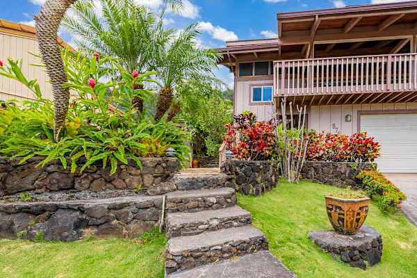 Tropical greenery adds warmth to the inviting exterior entrance