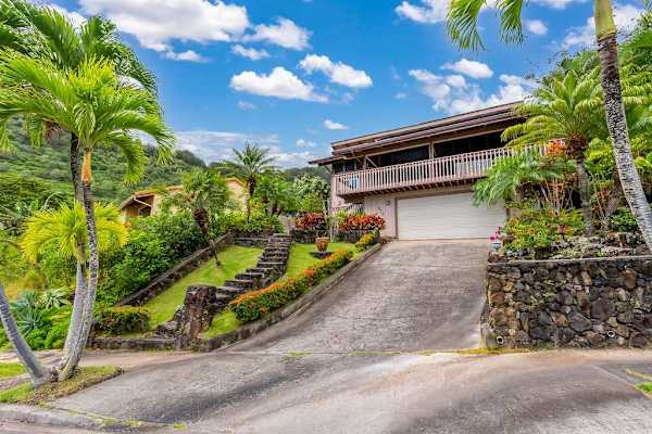 Welcoming entrance framed by lush greenery and a charming garden path
