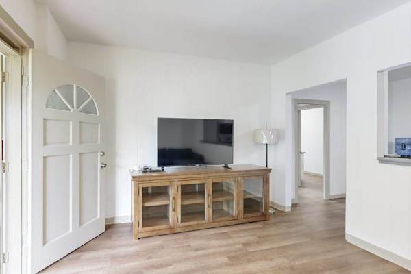Relax and enjoy your favorite shows in a comfortable living room with a TV.
