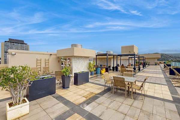 Sunny rooftop pool deck with relaxing shaded seating