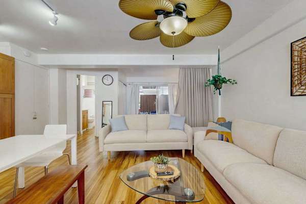 Unwind in this inviting living room with a cozy setup, entertainment options, and a refreshing ceiling fan.