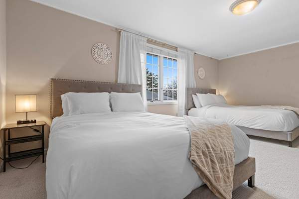 Bedroom #2 is furnished with two queen beds, enveloped in a tranquil ambiance highlighted by soft, ambient lighting for a peaceful night's sleep.