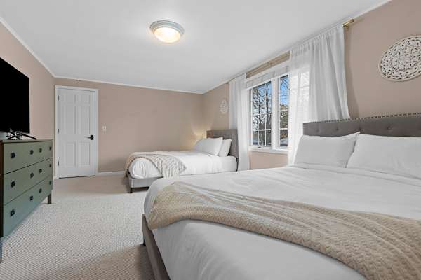 Bedroom #2 is furnished with two queen beds, enveloped in a tranquil ambiance highlighted by soft, ambient lighting for a peaceful night's sleep.