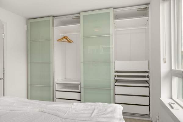 Closet with hangers and extra storage below. Unpack and stay organized.