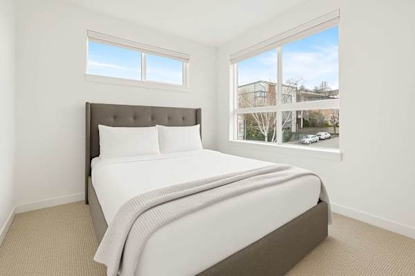Bright second bedroom with a queen bed and soft carpet. Comfortable and quiet.