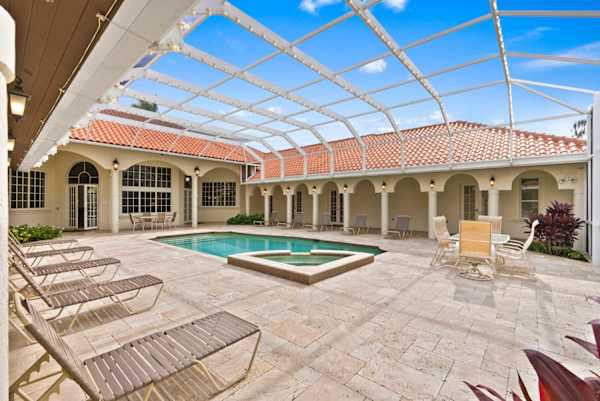Outdoor area with heated pool and hot tub, dining tables, lounge chairs and a grill