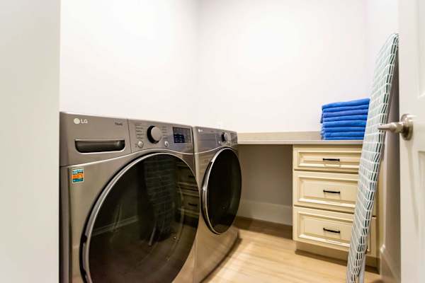 Laundry room with new front load washer and dryer and folding counter.