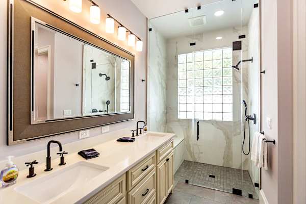 Master bathroom with double vanity, zero threshold walk-in shower and walk-in closet.