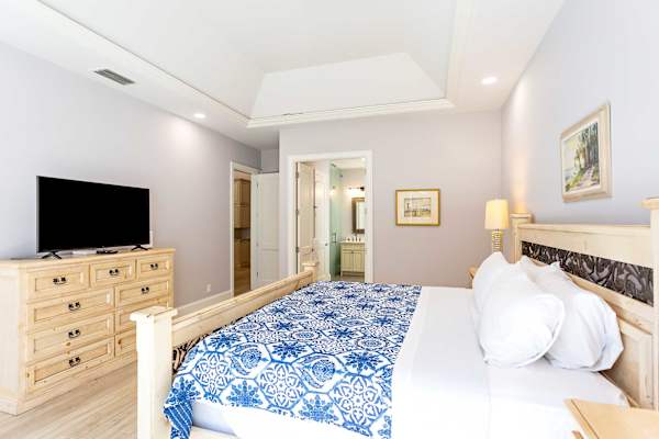 Master bedroom with king bed, tv and entrance to the pool