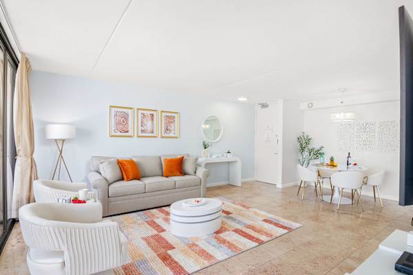Living room with pull-out sleeper sofa, a coffee table, and 2 arm barrel chairs with tufted backs.