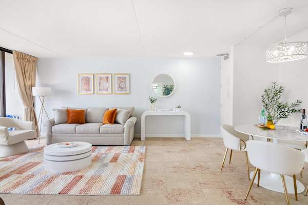 Living room with pull-out sleeper sofa, a coffee table, and 2 arm barrel chairs with tufted backs.