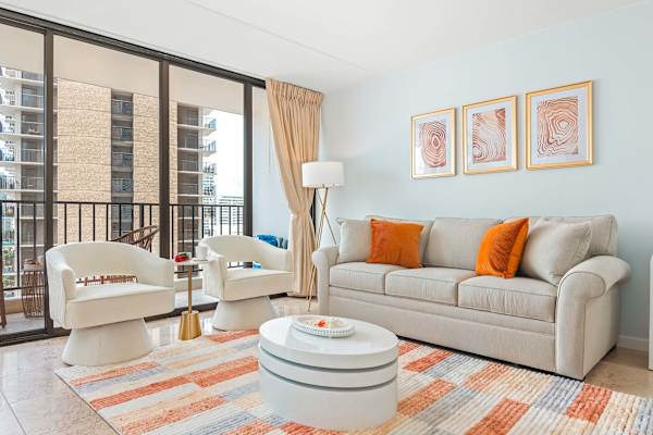 Living room with pull-out sleeper sofa, a coffee table, and 2 arm barrel chairs with tufted backs.