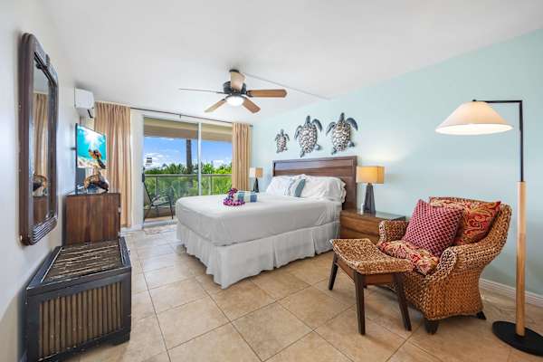 Relax in the airy, wide second bedroom—ample space to unwind, a TV for entertainment, and an easy access to the balcony, framing serene nature views on calmer days.