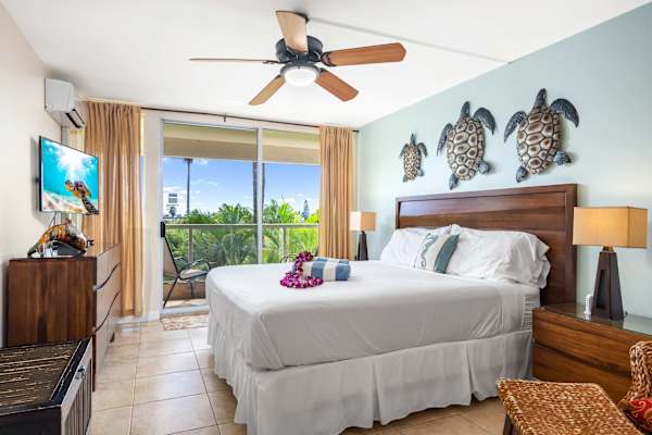 Relax in the airy, wide second bedroom—ample space to unwind, a TV for entertainment, and an easy access to the balcony, framing serene nature views on calmer days.