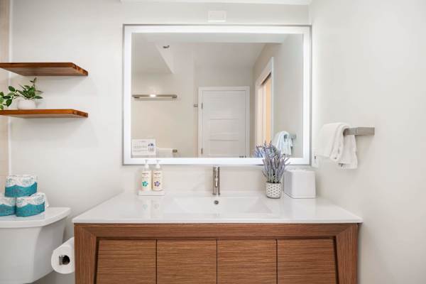 Your full bathroom has an LED mirror and cabinets for storage