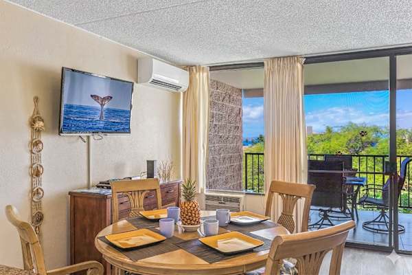 Bright dining area w/ TV & sliding doors opening to the lanai, split AC