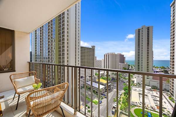 Sip a quick coffee or unwind at sunset on the cozy balcony—two outdoor seats and a table with sweeping city and ocean views.