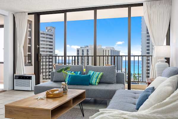 Settle in this cozy living space with two comfortable reclining sofas and an air conditioner, plus enjoy stunning city views from the balcony right next to your living room.