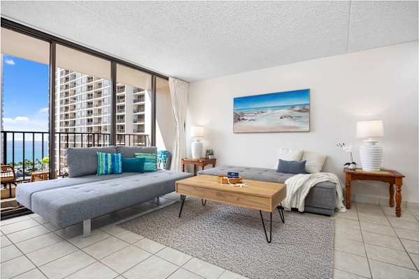 Settle in this cozy living space with two comfortable reclining sofas and an air conditioner, plus enjoy stunning city views from the balcony right next to your living room.