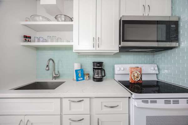 This kitchen is equipped with a stove and microwave for easy meal prep and added convenience.