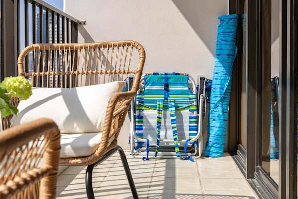 Sip a quick coffee or unwind at sunset on the cozy balcony—two outdoor seats and a table with sweeping city and ocean views.