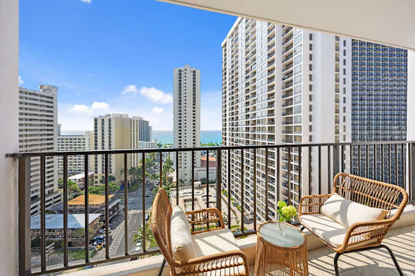 Sip a quick coffee or unwind at sunset on the cozy balcony—two outdoor seats and a table with sweeping city and ocean views.