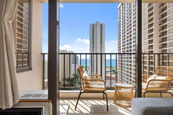 Sip a quick coffee or unwind at sunset on the cozy balcony—two outdoor seats and a table with sweeping city and ocean views.