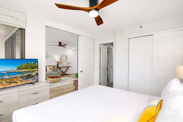 Bedroom view toward living area w/ TV console & open layout