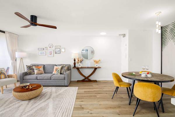 Airy living room w/ comfy sofa, accent chairs & dining table for shared meals