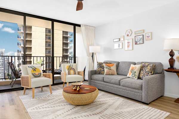 Cozy living area w/ sofa, accent chairs & balcony doors bringing in natural light