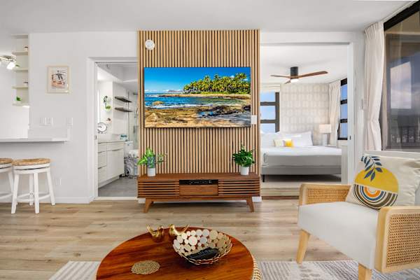Open living area featuring a large TV wall & stylish wood accent panel