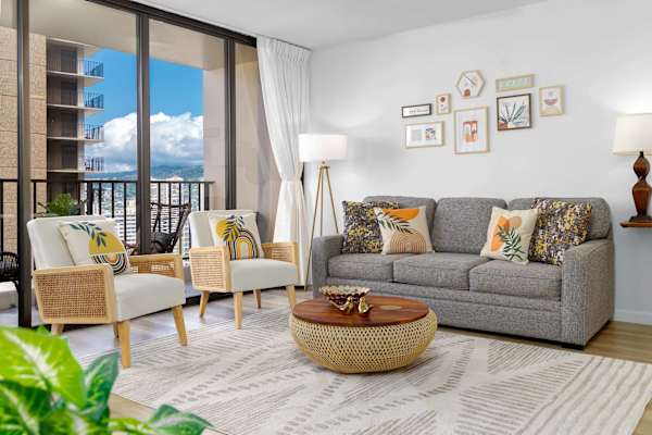 Cozy living area w/ sofa, accent chairs & balcony doors bringing in natural light