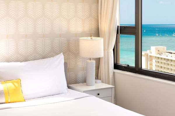 Bedside view w/ soft lamp light & sweeping ocean scenery beyond the window