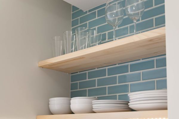 Open kitchen shelving w/ neatly arranged plates, bowls & glassware