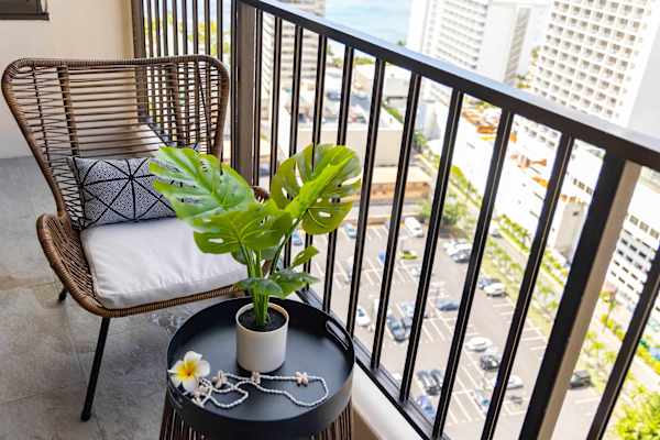 Cozy balcony corner w/ chair, side table & leafy plant