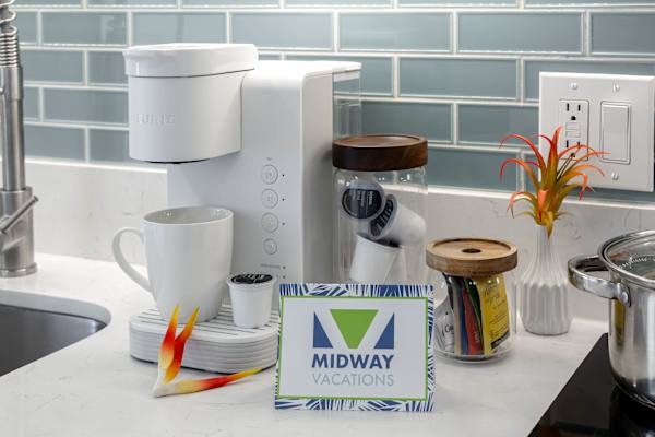 Kitchen counter stocked w/ coffee maker, mugs & essentials for easy mornings
