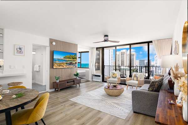 Spacious living area w/ dining table & wall-to-wall windows overlooking the city