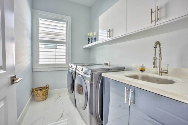 Functional Laundry Room Equipped With Washer And Dryer, Sink And Cabinets For Convenient Storage And Everyday Use