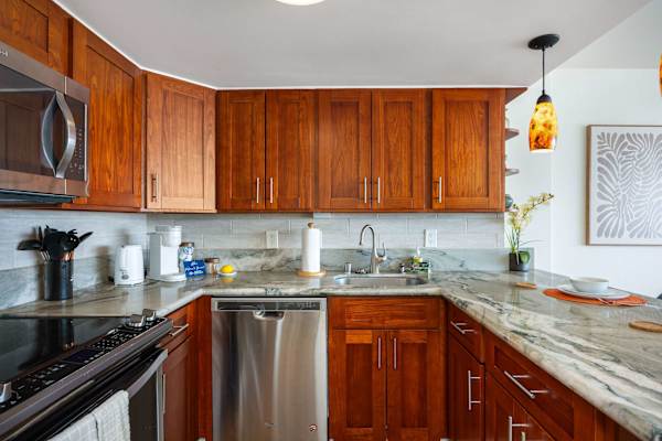 A fully appointed stainless‑steel kitchen, complete with a microwave, stove, refrigerator with freezer, and dishwasher.