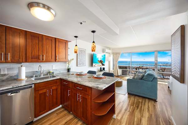 A fully appointed stainless‑steel kitchen, complete with a microwave, stove, refrigerator with freezer, and dishwasher.