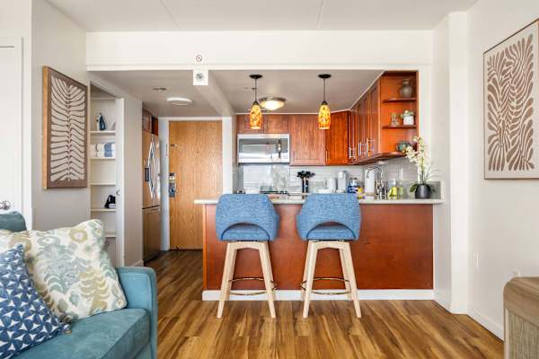 The kitchen counter doubles as a cozy dining spot for two, perfect for meals or quick morning coffee.