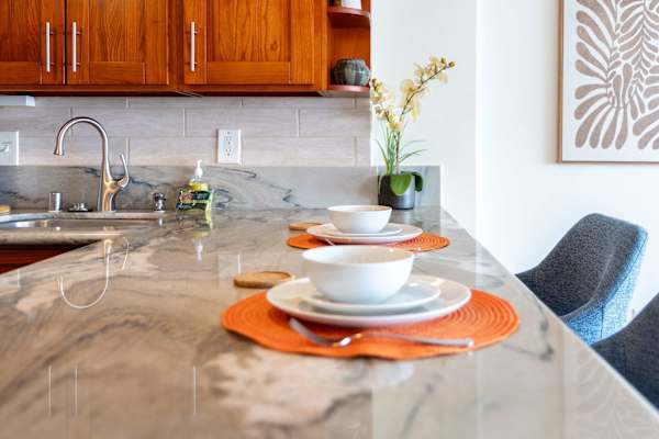 The kitchen counter doubles as a cozy dining spot, perfect for meals or quick morning coffee.