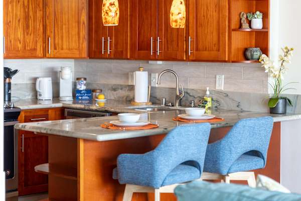 The kitchen counter doubles as a cozy dining spot, perfect for meals or quick morning coffee.
